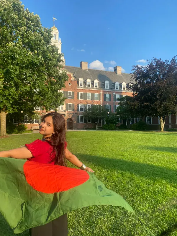 Avec le drapeau du Bangladesh devant le campus